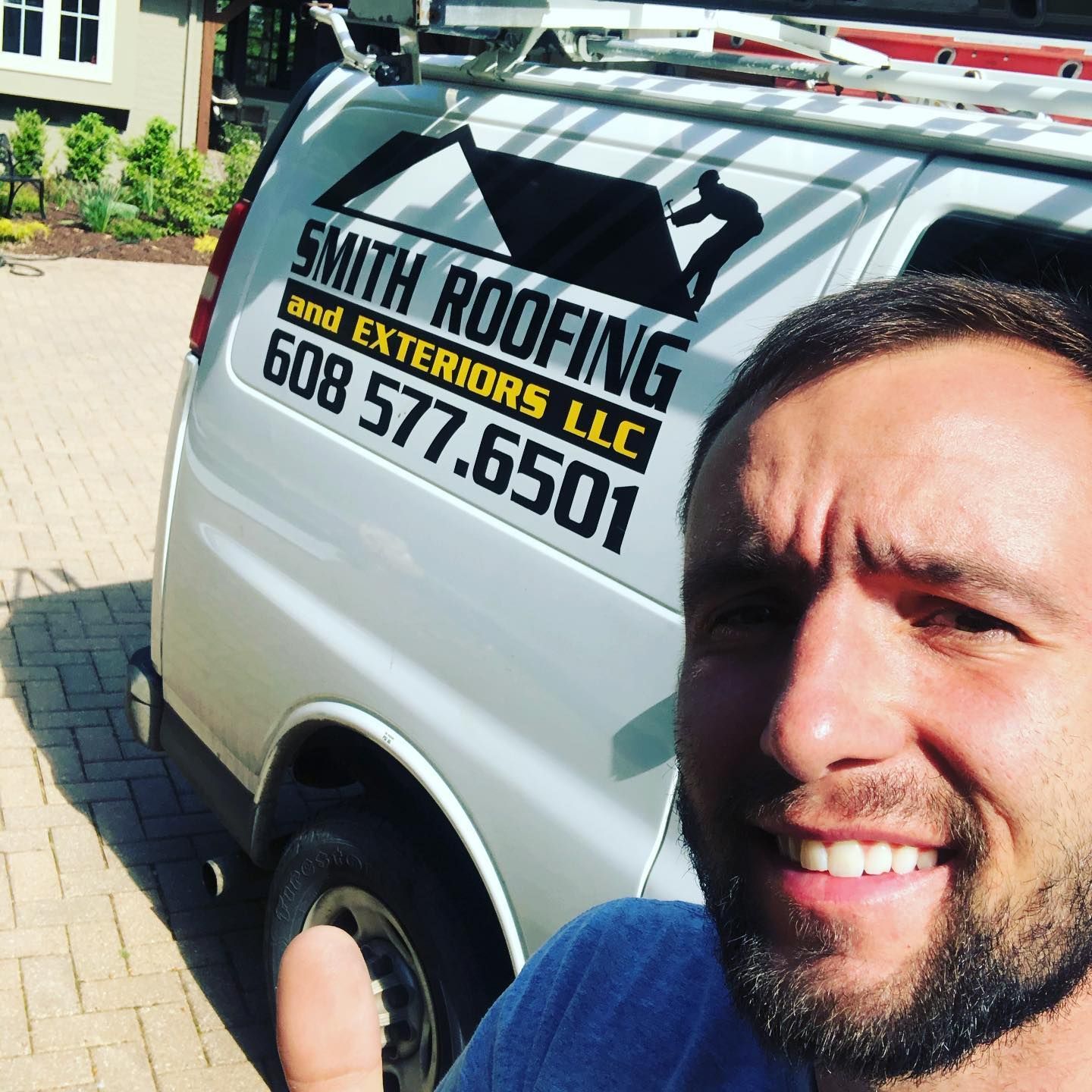 owner standing in front of a van that says smith roofing and exteriors llc