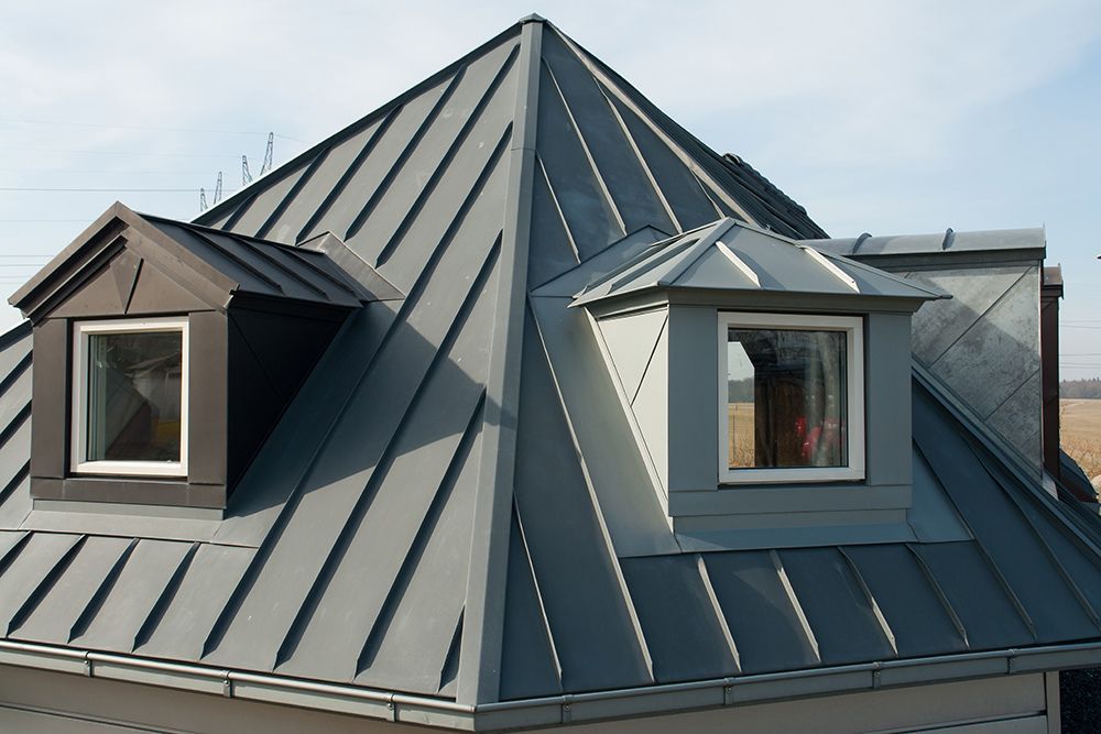 Two men are working on a metal roof.