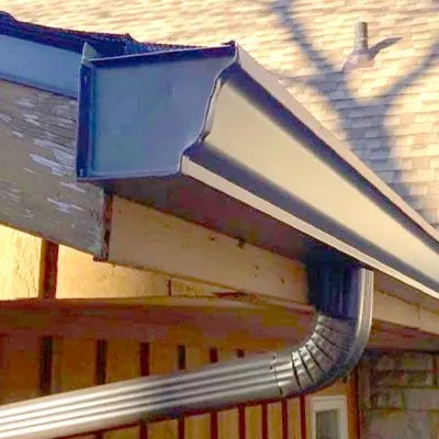 A close up of a gutter on the side of a house.