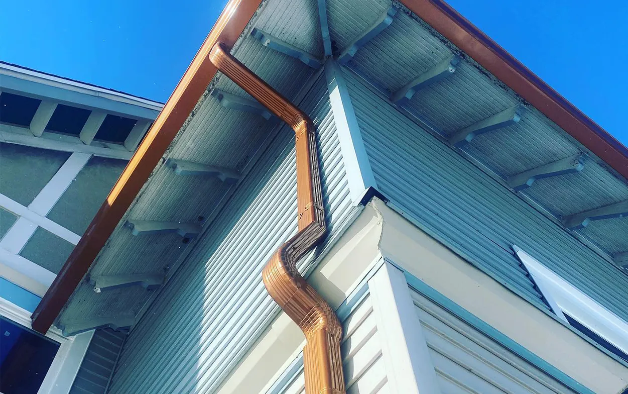 A house with a wooden gutter on the side of it