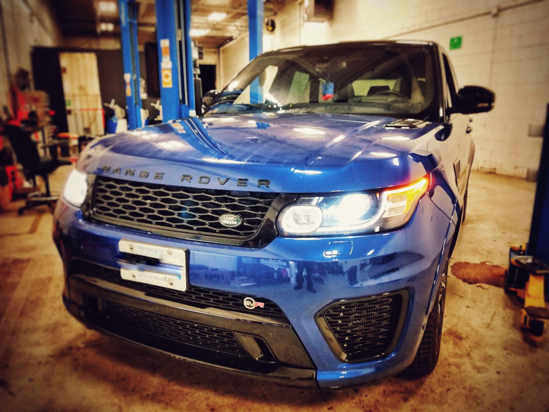 Blue Range Rover Sport SUV in a garage, under a lift. | Mecano Autoworks