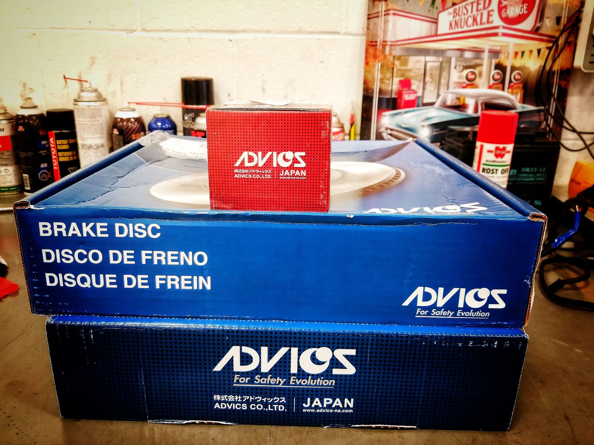 Two Advics brake disc boxes, one on top of the other, with a smaller red Advics box on top.