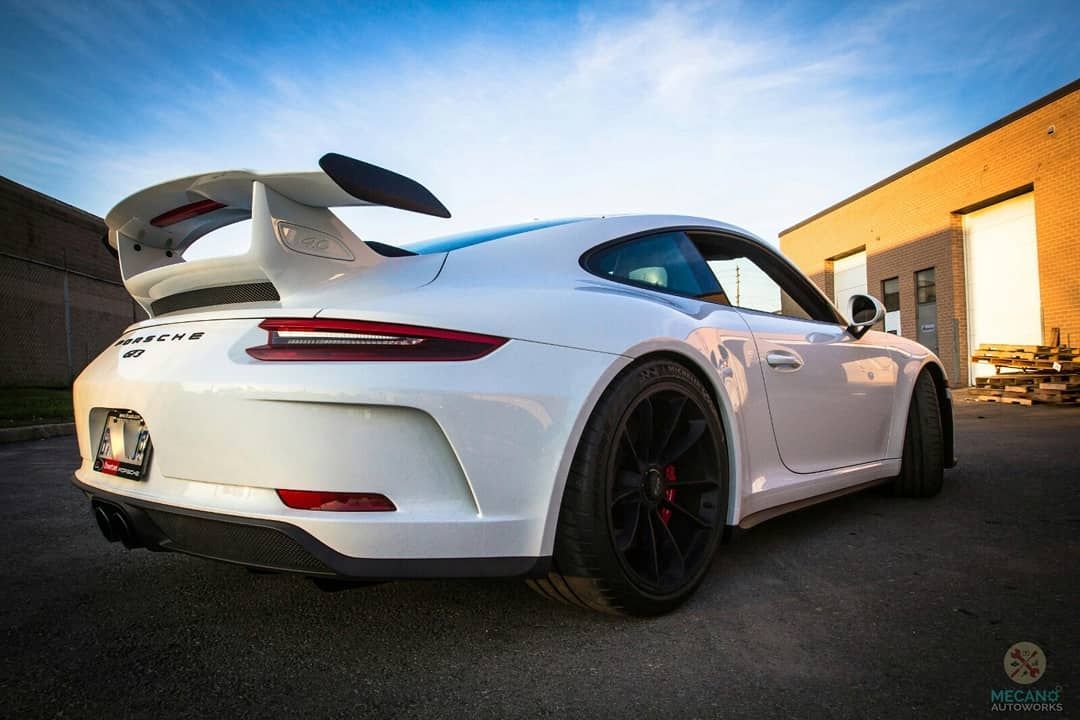 White Porsche sports car with a large spoiler parked outdoors. | Mecano Autoworks