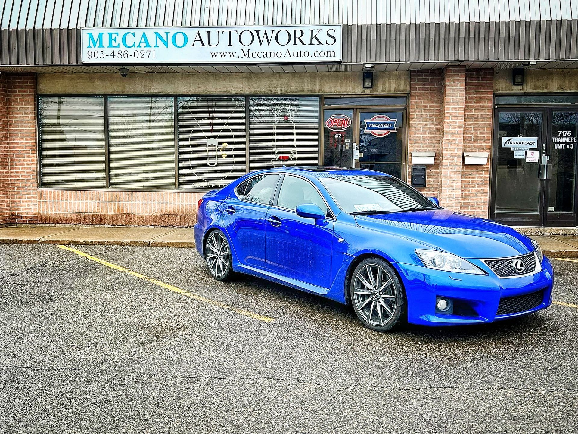 Blue Lexus sedan parked in front of Mecano Autoworks shop. | Mecano Autoworks