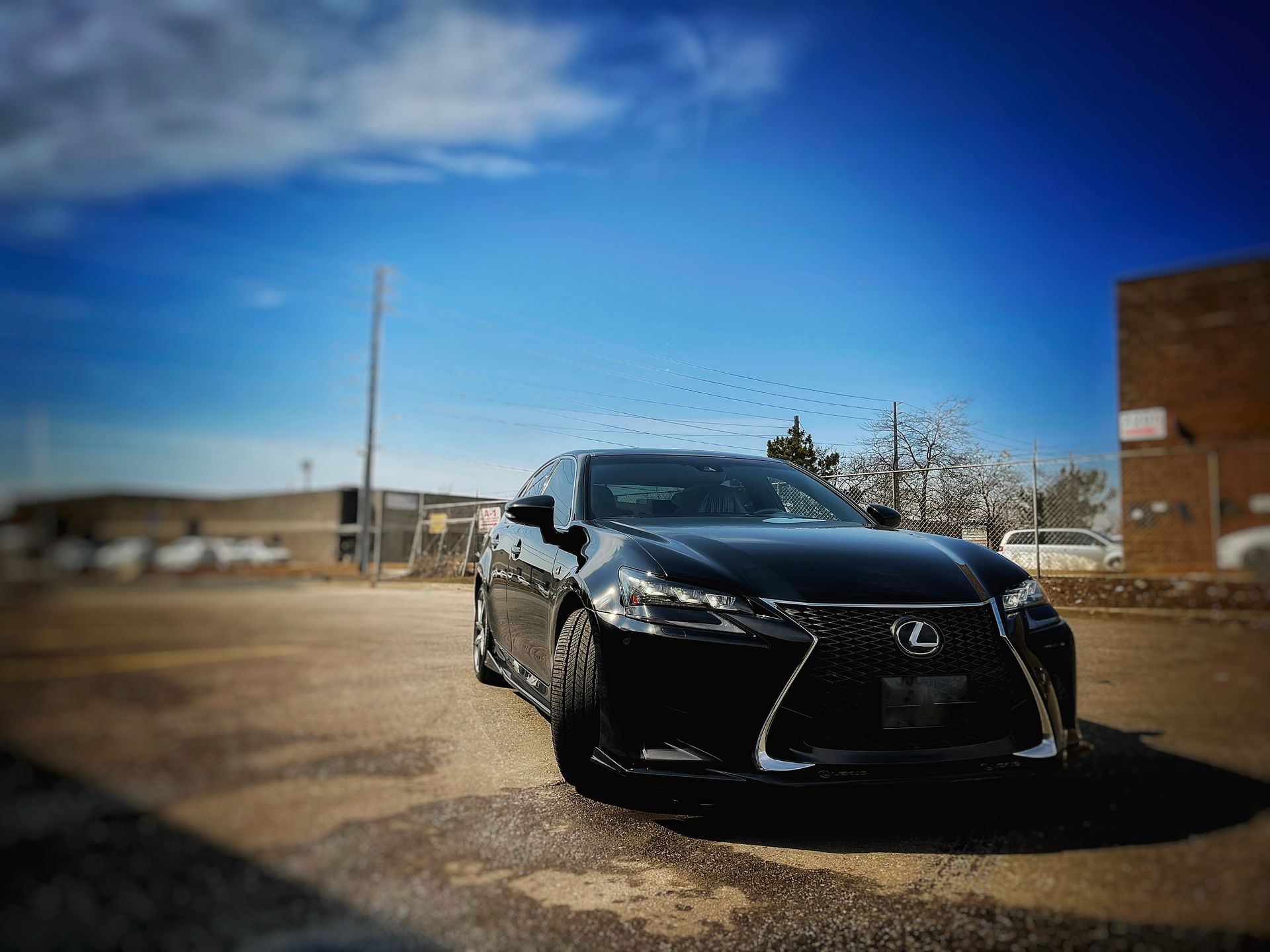 Black Lexus sedan parked in an empty lot on a sunny day. | Mecano Autoworks
