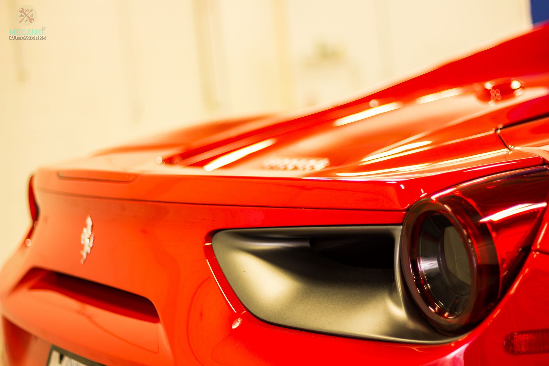 Red Ferrari sports car, close-up of the rear with taillight detail. | Mecano Autoworks