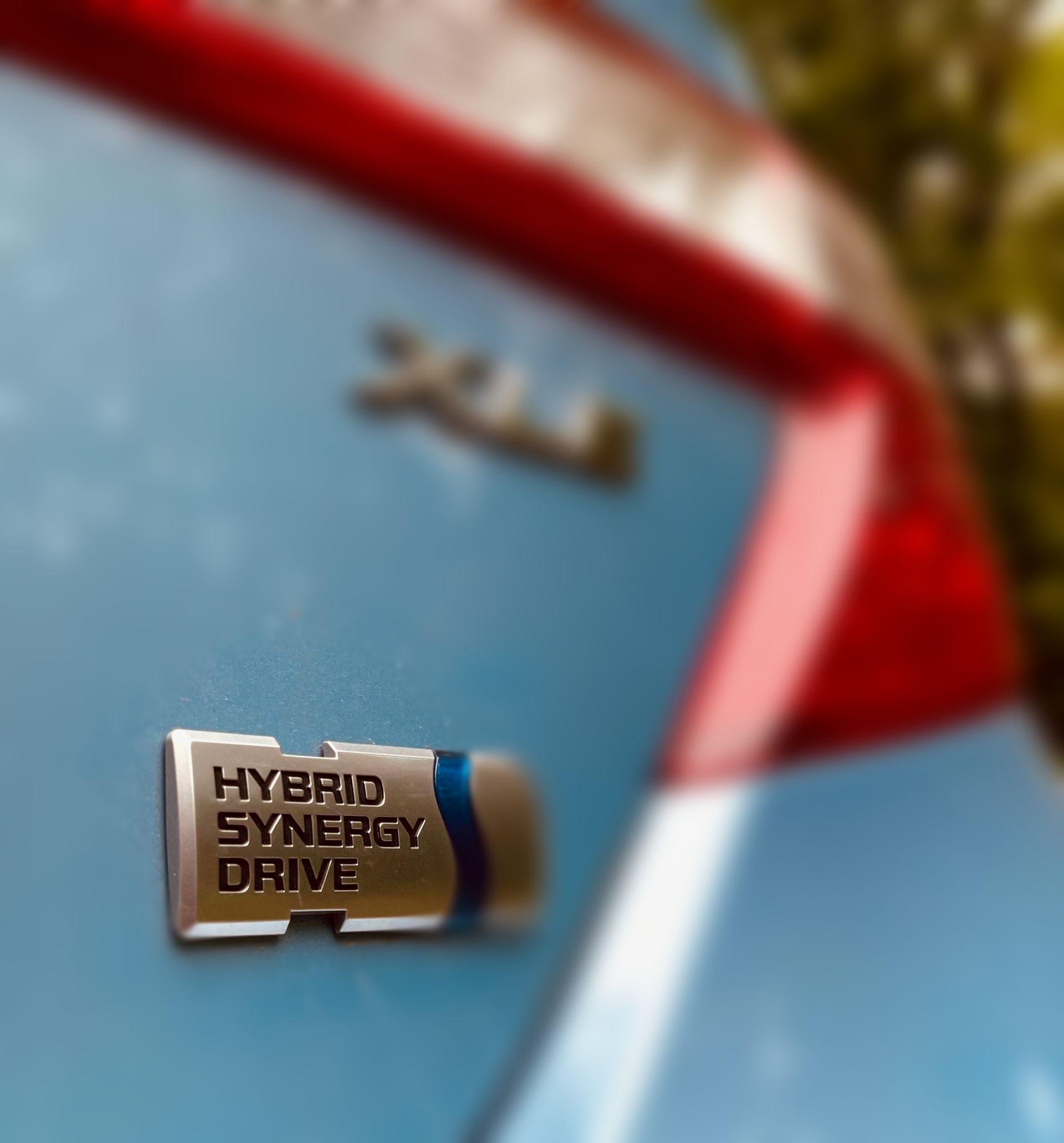 Rear Hybrid Synergy Drive Emblem on a blue 2013 Toyota Camry Hybrid XLE. Image taken at Bon Echo Provincial Park