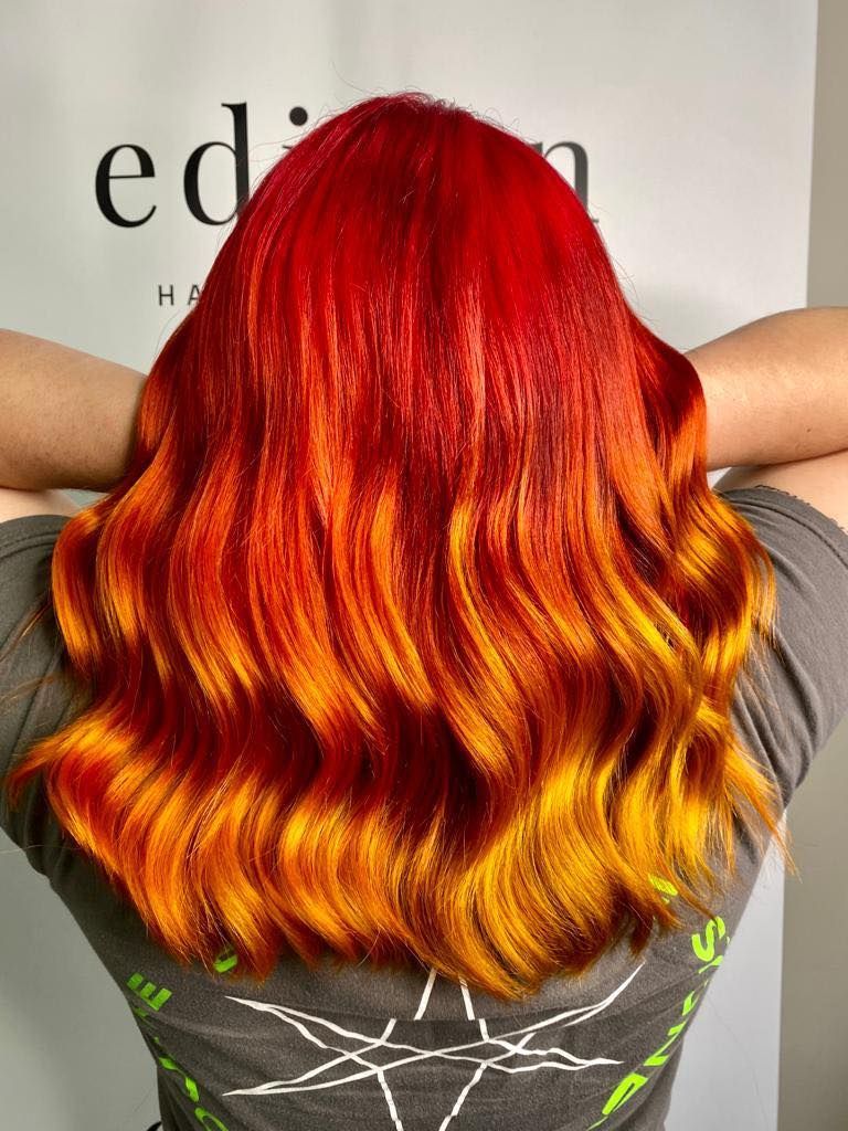 Woman With Red to Yellow Ombre Wavy Hair, Arms Resting Behind Head — EDISON Hair Collective In Mackay, QLD
