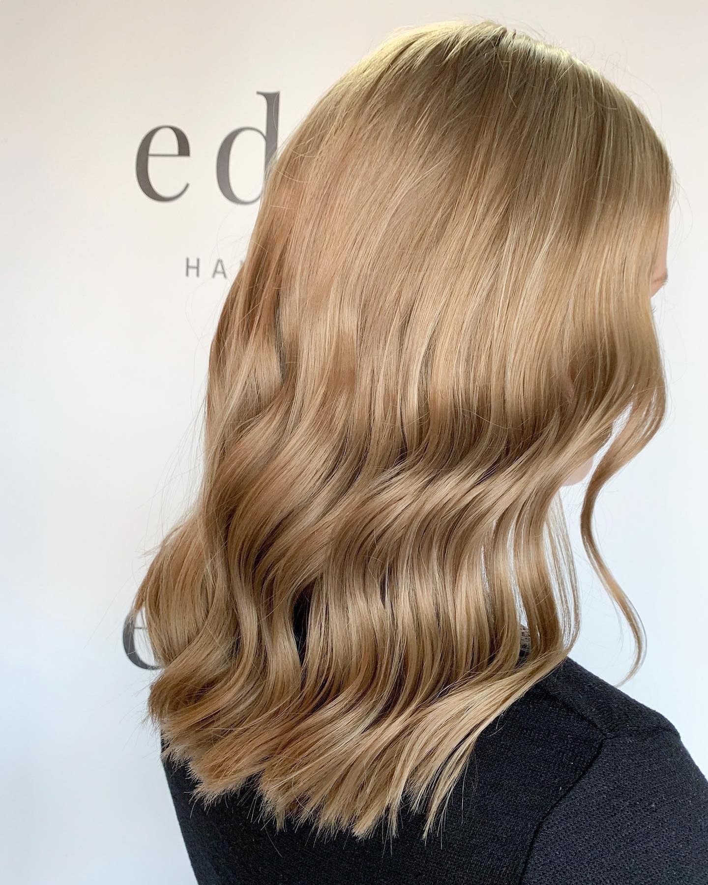 Shoulder-Length Wavy Light Brown Hair Styled on A Person, Dark Top, Against a White Background — EDISON Hair Collective In Mackay, QLD