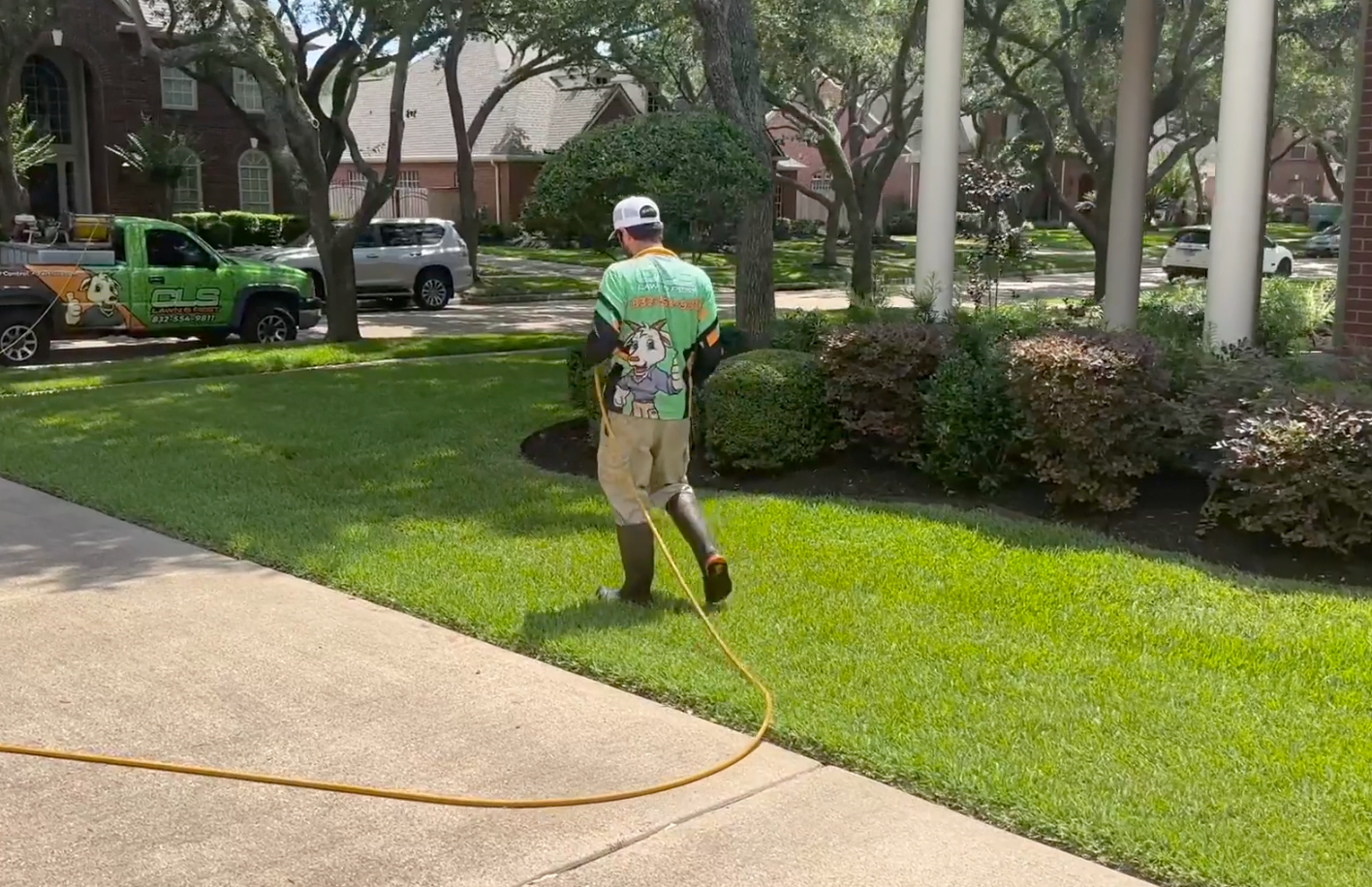 A man is spraying a lawn with a hose.