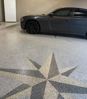 A car is parked in a garage with a star on the floor.