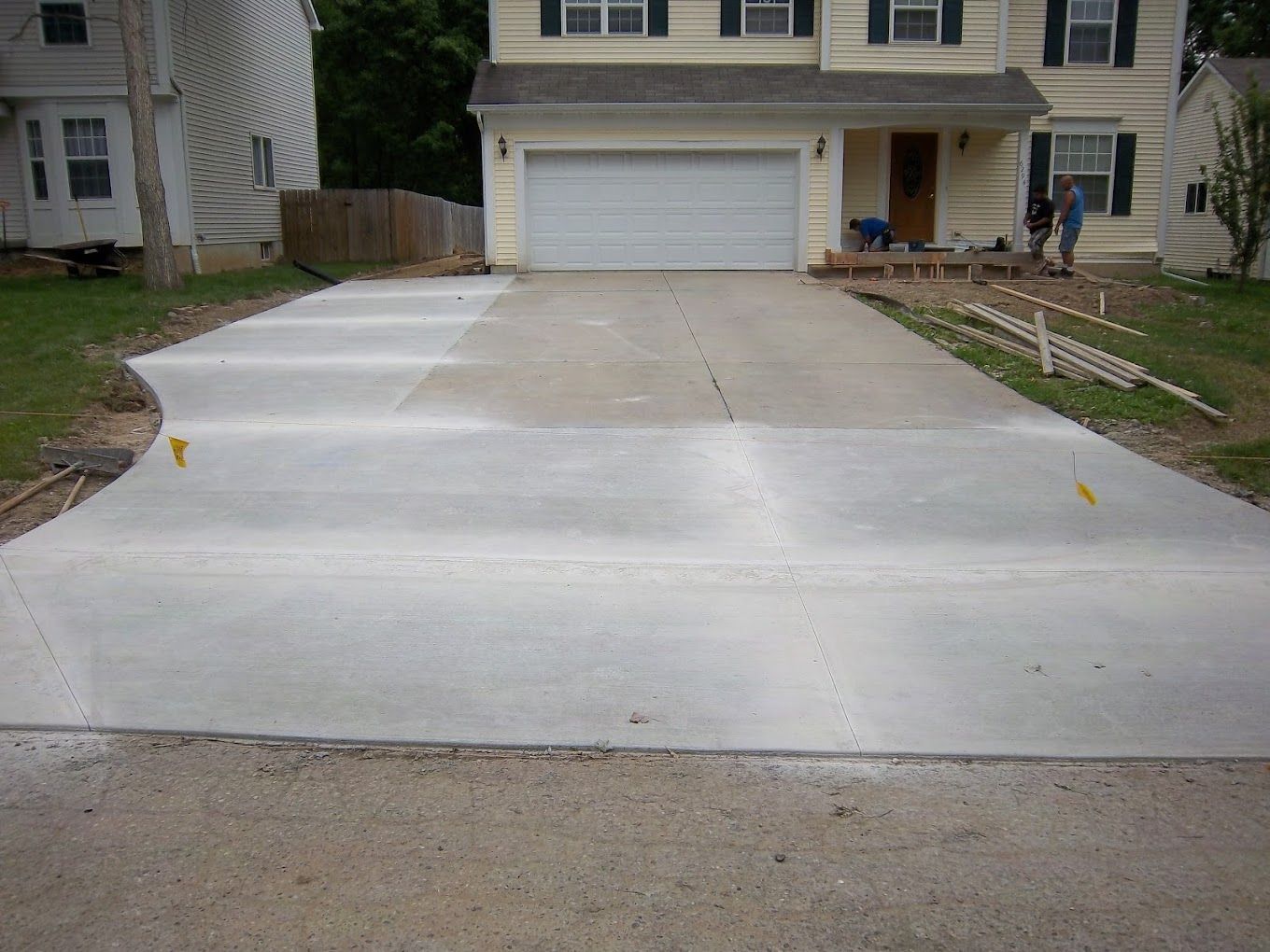 A concrete driveway is being built in front of a house