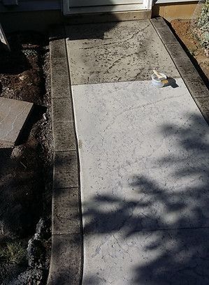 A concrete walkway with a shadow of a tree on it.
