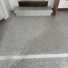 A close up of a concrete floor with stairs in a room.