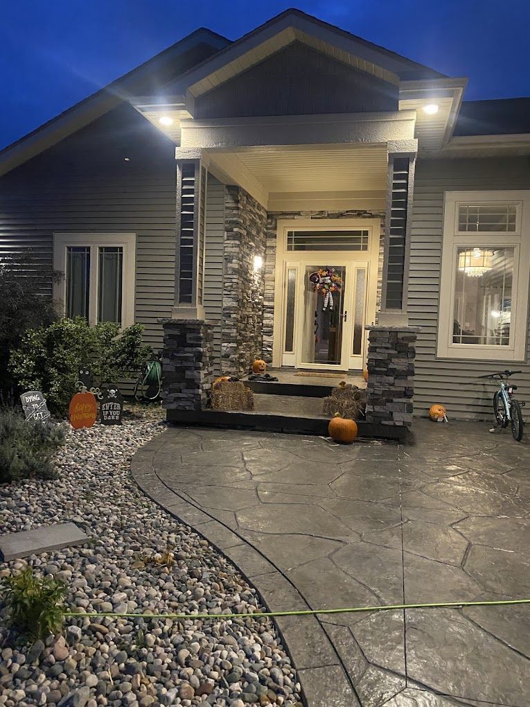 A house with pumpkins in front of it is lit up at night.