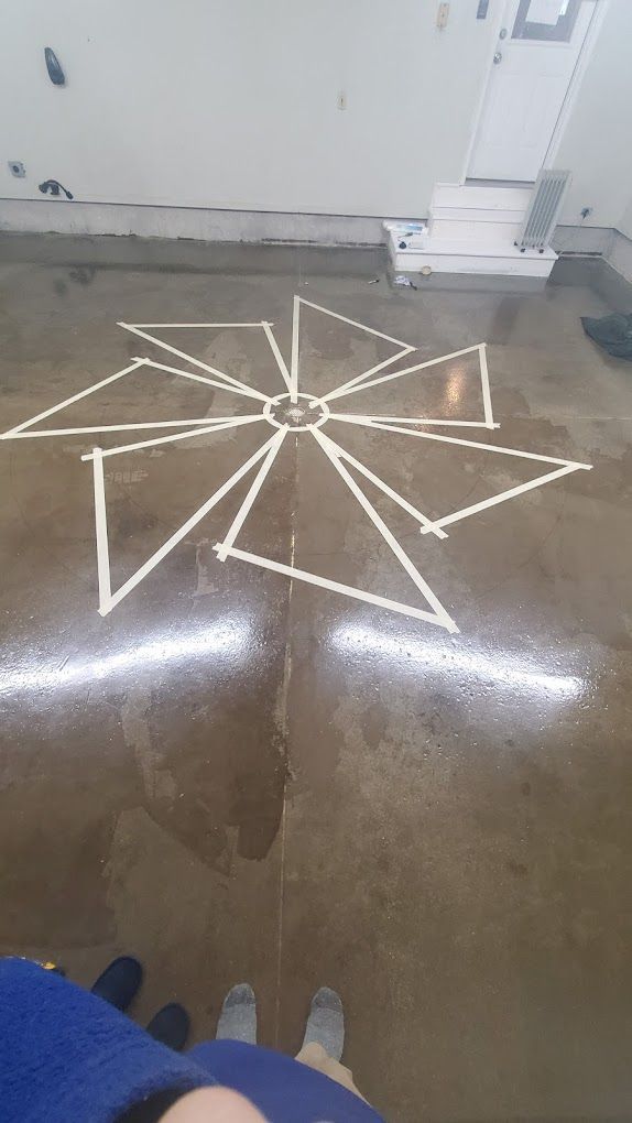 A person is standing in front of a drawing on the floor.