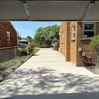 A view of a driveway leading to a brick house from a garage door.