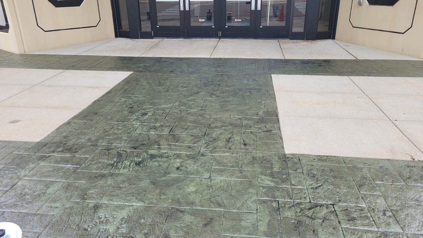 A green and white tiled floor in front of a building.