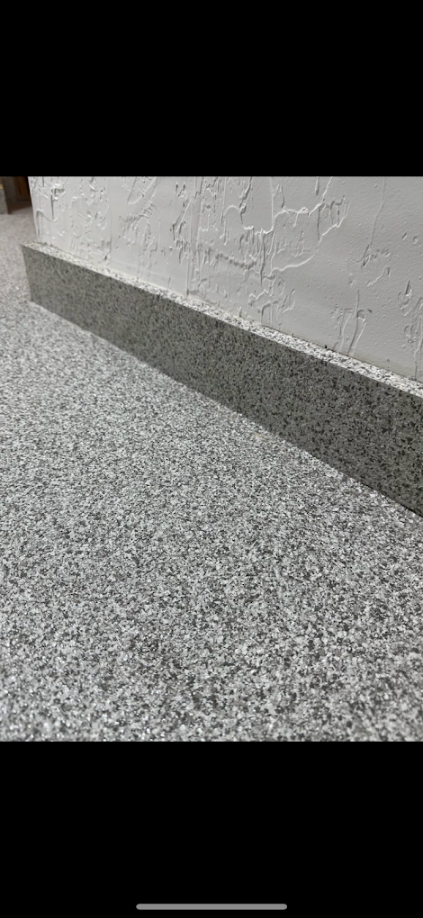 A close up of a gray carpet on a floor.