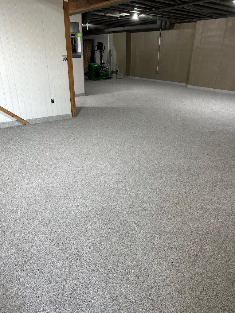 A large empty basement with a carpeted floor and stairs.