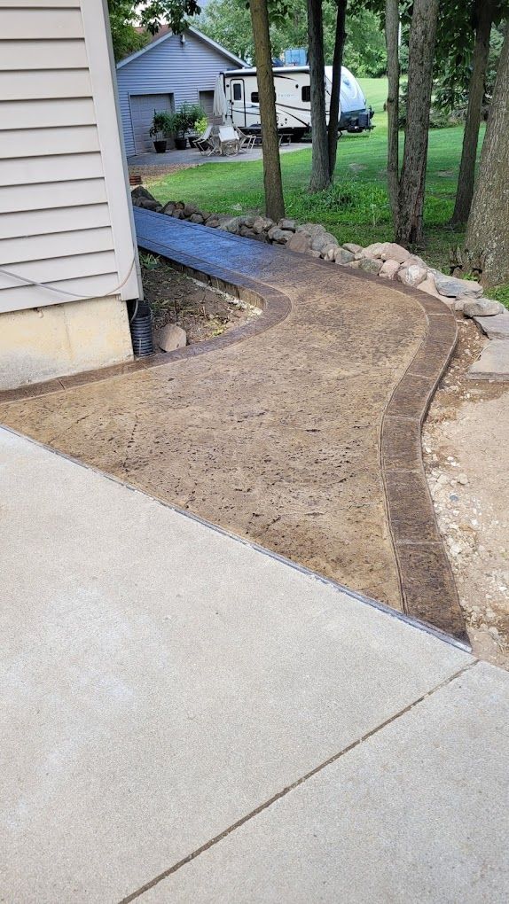 A concrete walkway is being built in front of a house.