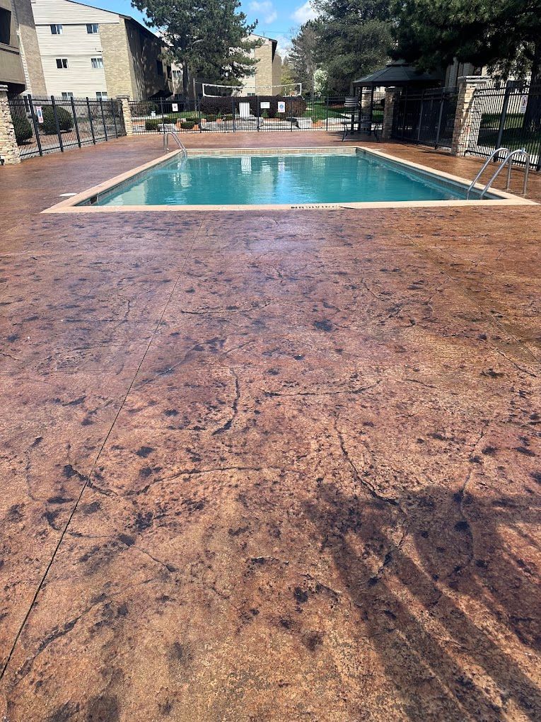 A large swimming pool is surrounded by a concrete deck.