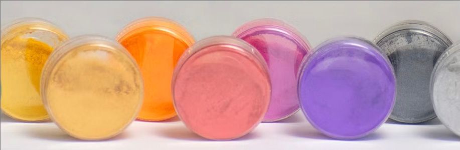 A row of soaps of different colors are lined up on a table.