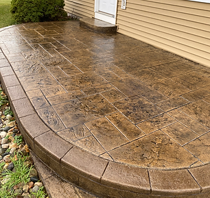 A concrete porch with steps leading to a house.