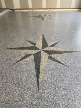 A compass rose is painted on the floor of a garage.