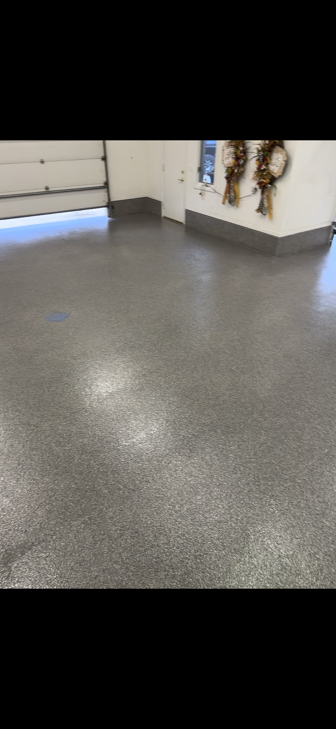 A garage with a gray floor and a garage door.
