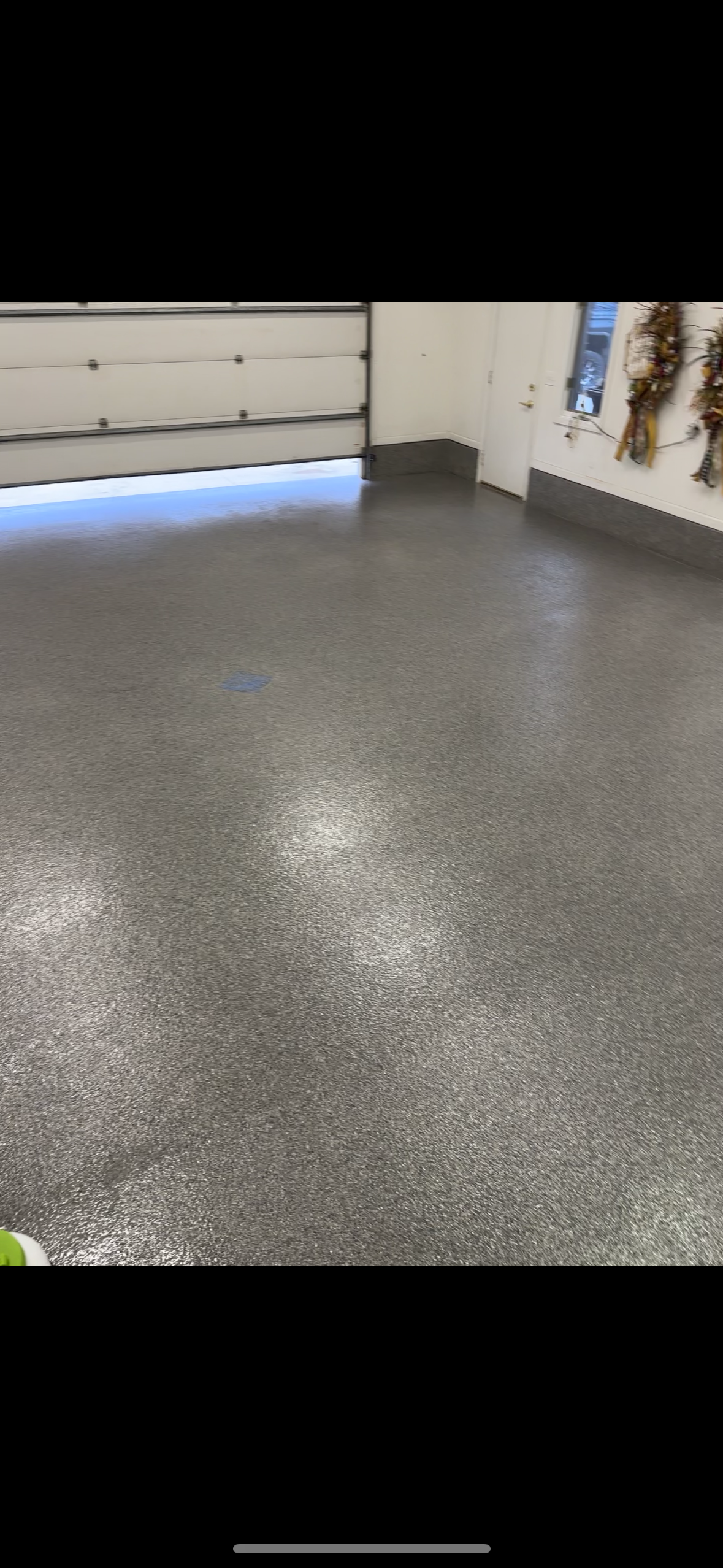 A garage with a gray floor and a garage door.