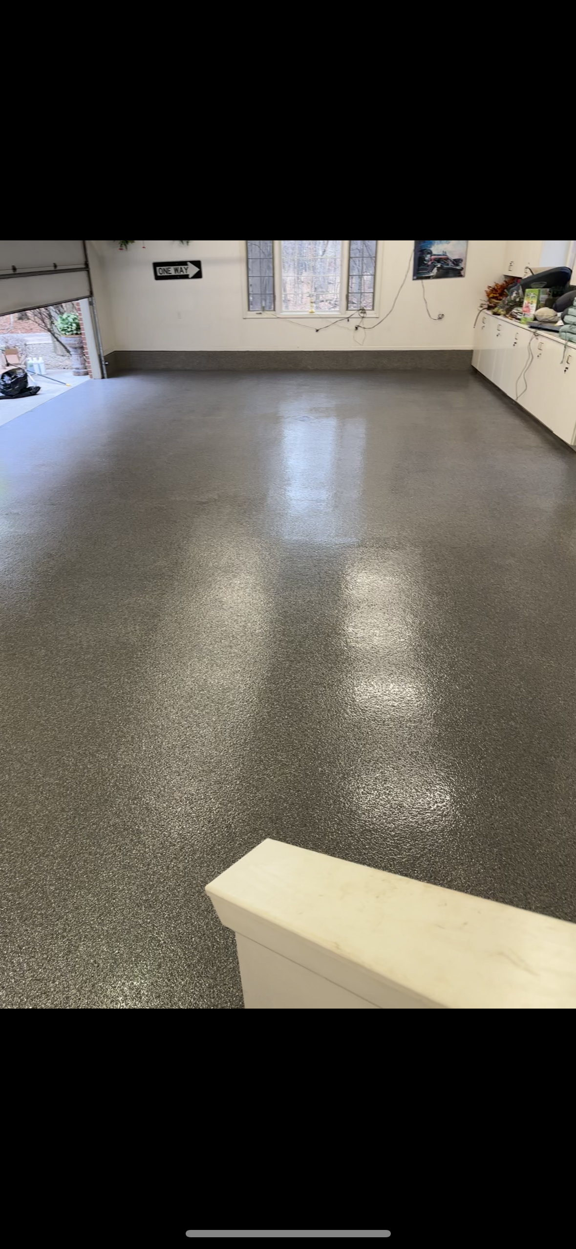 A garage with a shiny floor and a garage door.