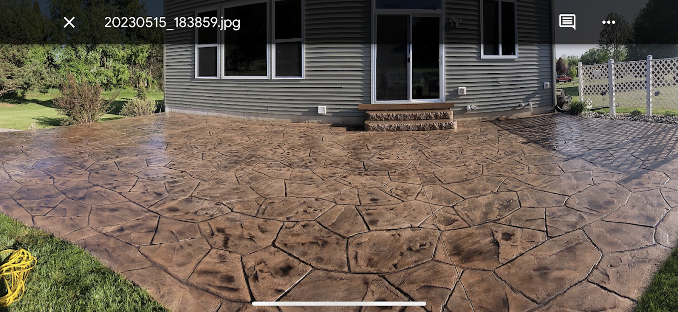 A picture of a house with a patio in front of it.