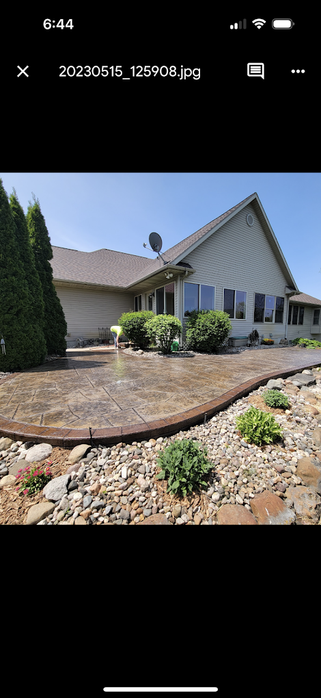 A picture of a house with a concrete driveway in front of it.