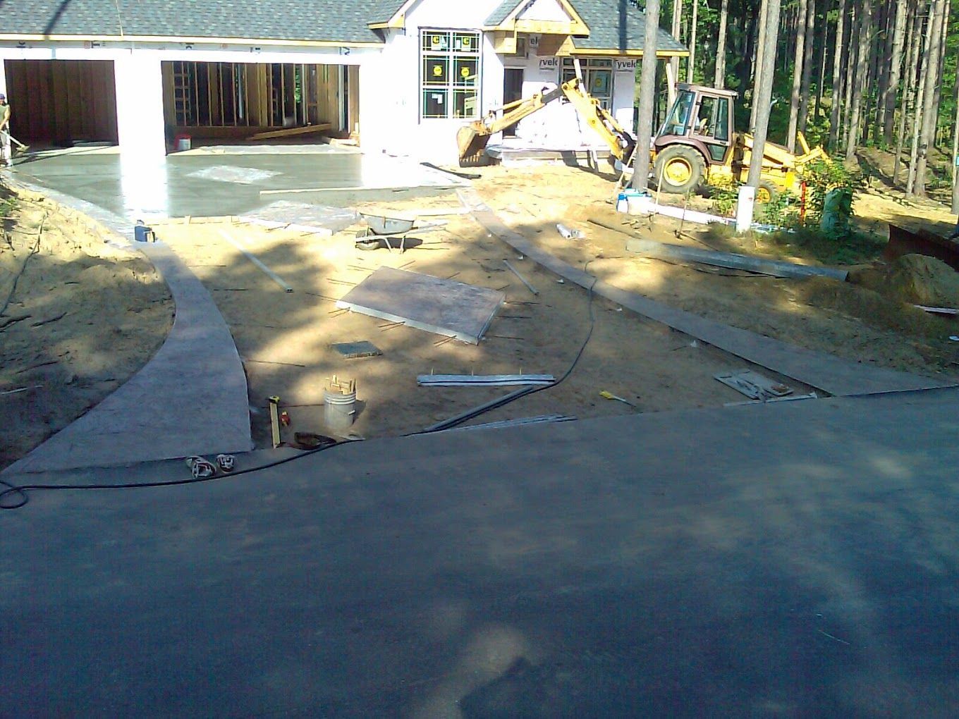 A house under construction with a concrete driveway in front of it