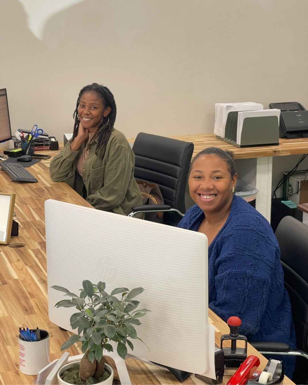 Man with crown holds Little Tikes car on a board, red shirt, blue jeans, red background.