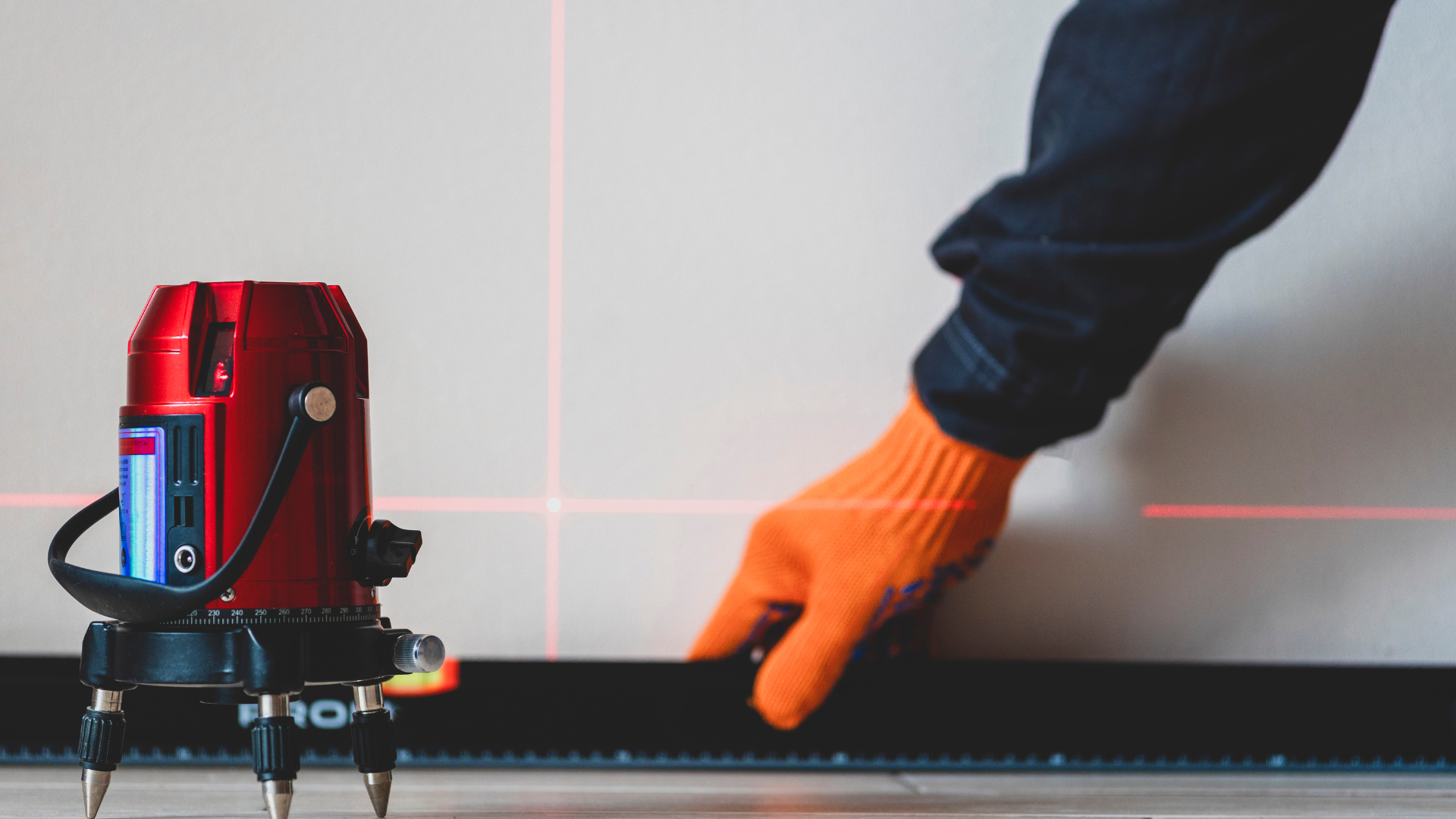 A person is measuring a wall with a laser level.