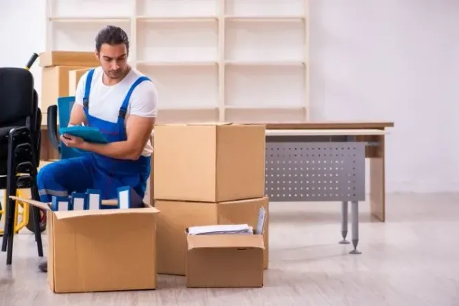 A professional mover organizing boxes in a bright, spacious office.