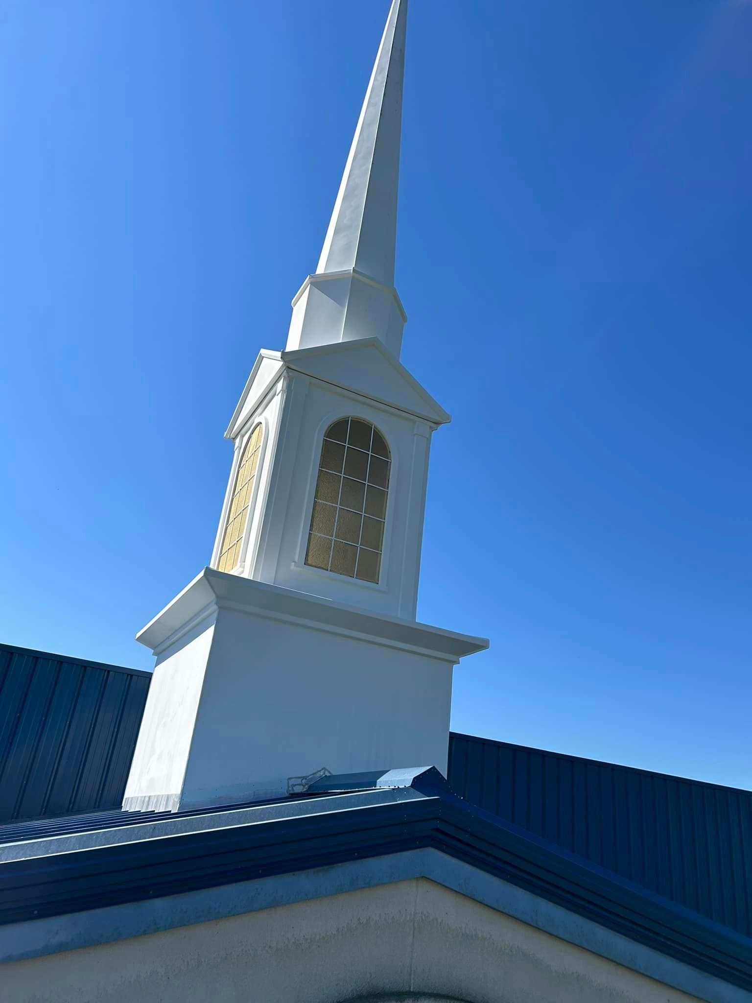 A church steeple with a blue sky in the background