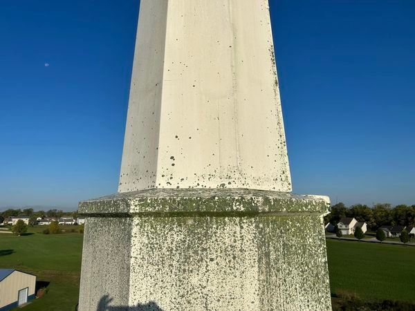 A white obelisk with a blue sky in the background