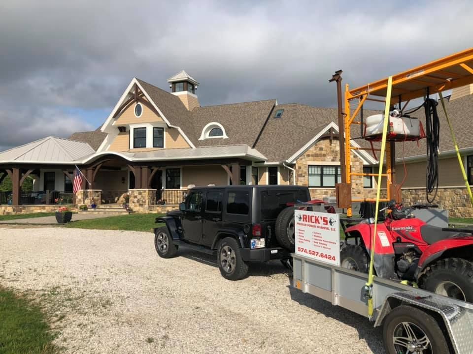 A large white house with a lot of windows and a grill in front of it.