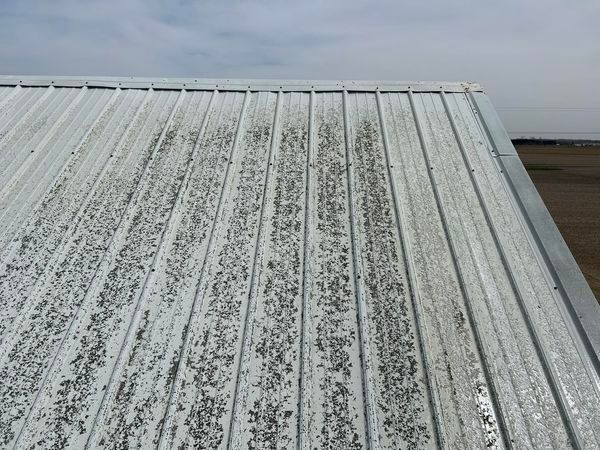 A close up of a white metal roof with a blue sky in the background.