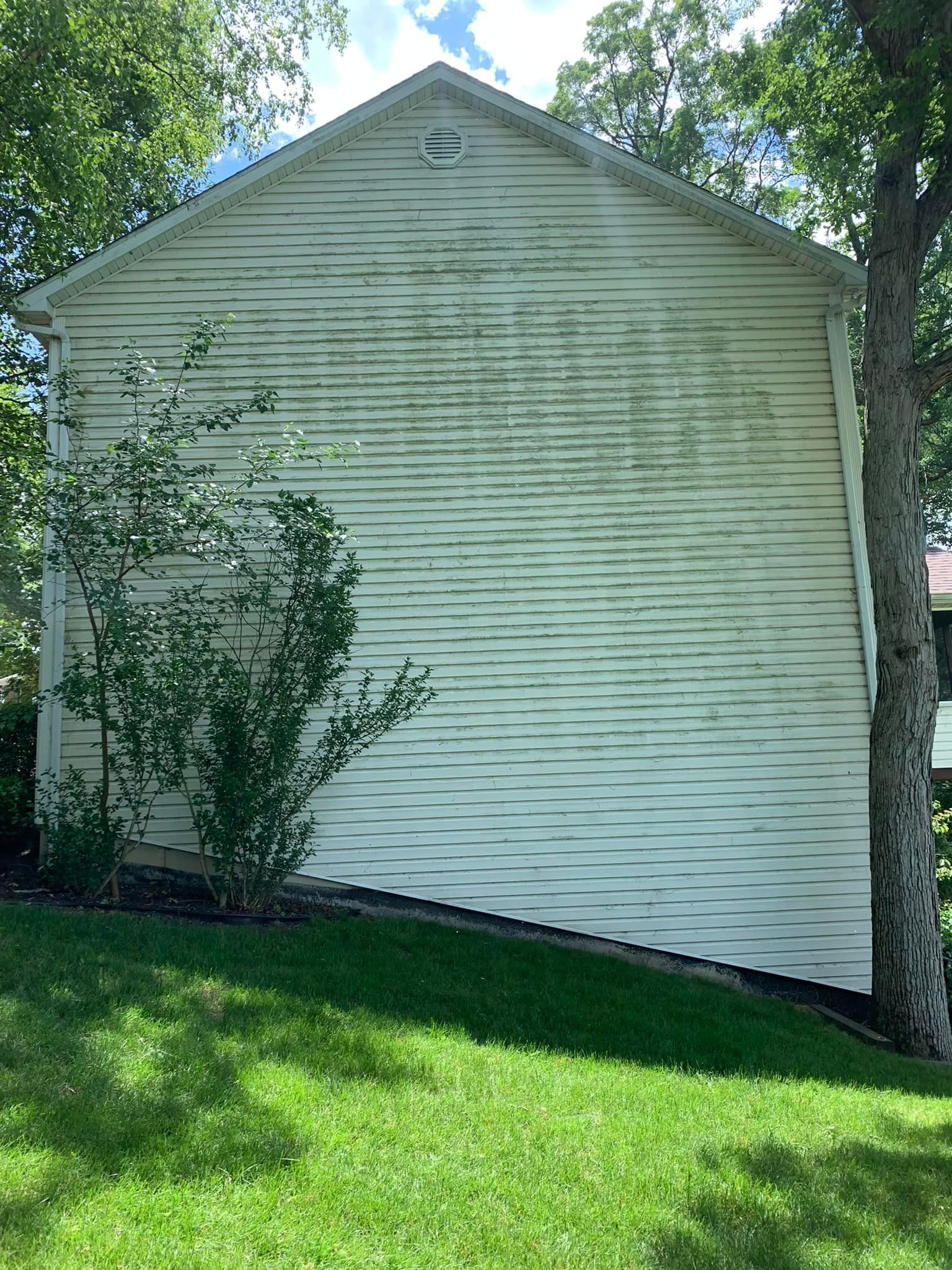 A white house with a tree in front of it.