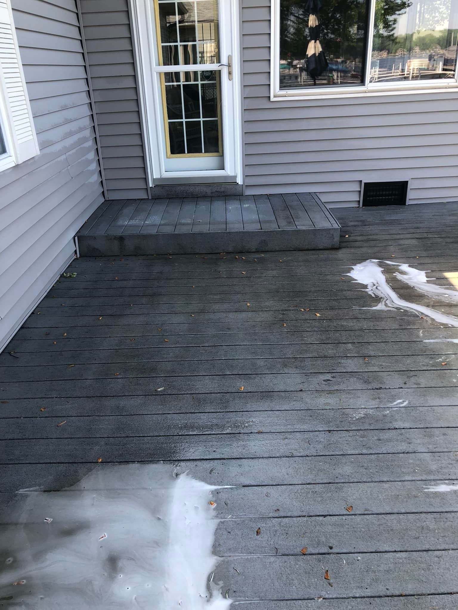 A house with a gray siding and a white door