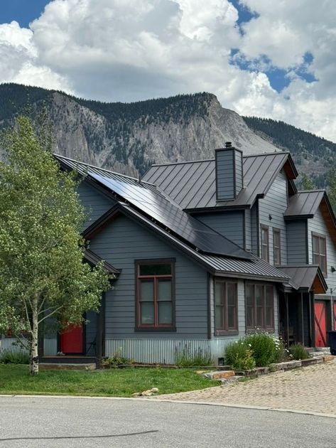 A large house is being built with a mountain in the background.
