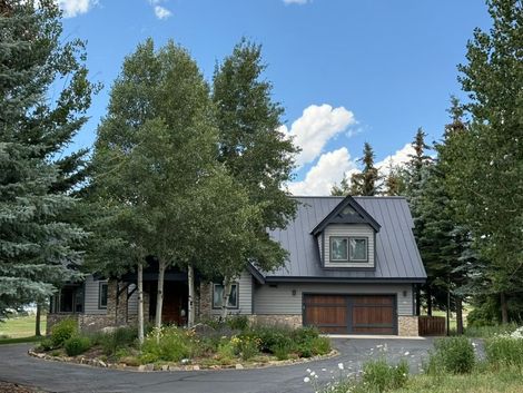 A large house with a metal roof is being built