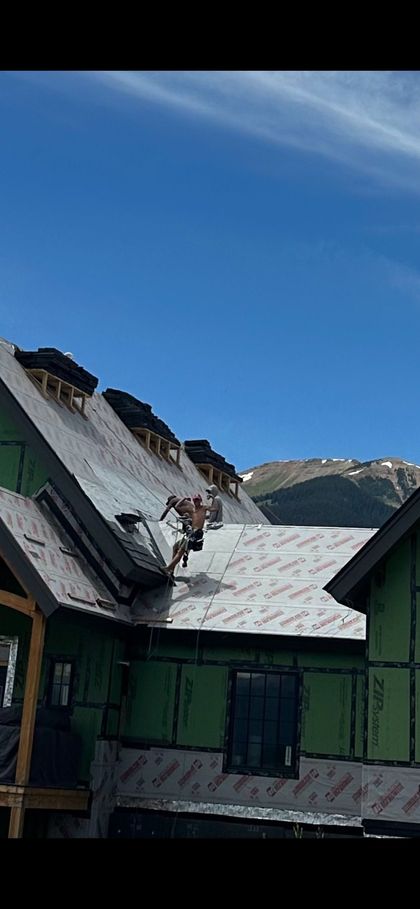 A man is working on the roof of a house under construction.