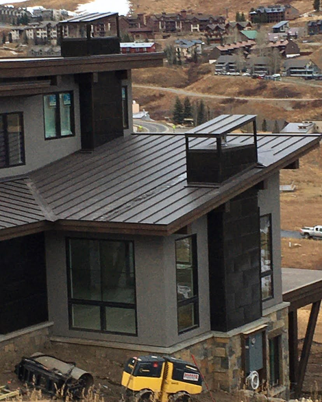 A large house with a metal roof is being built
