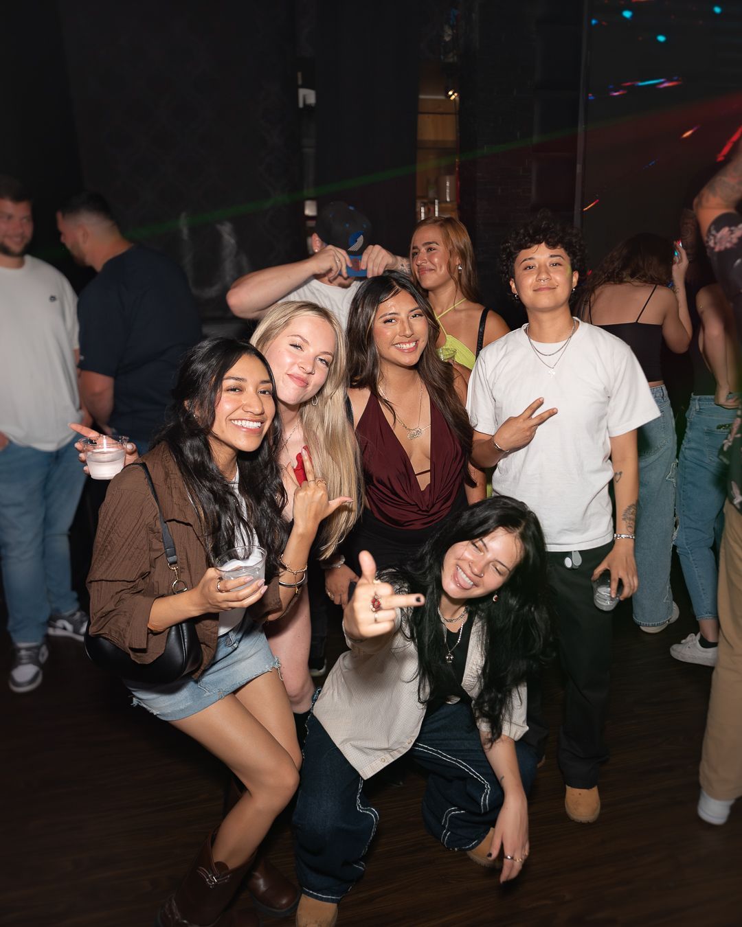A group of good looking friends are posing for a photo while having fun at the club.
