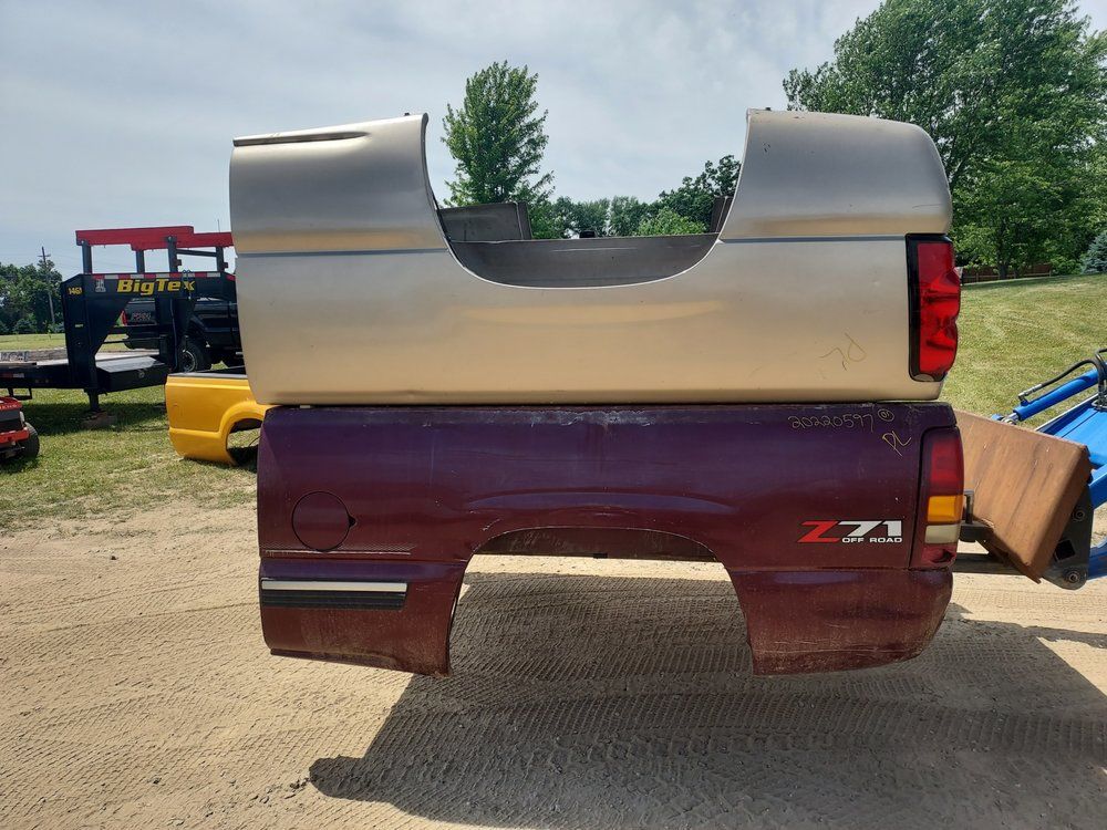 The back end of a truck is sitting on top of another truck.